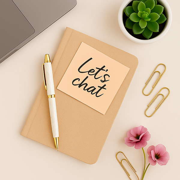 A phone, notepad and laptop on a desk
