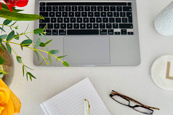 A desk scene with stationary and laptop